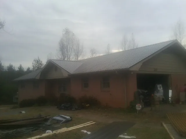 Gray metal roof on a stucco house with an attached garage in Hollandale