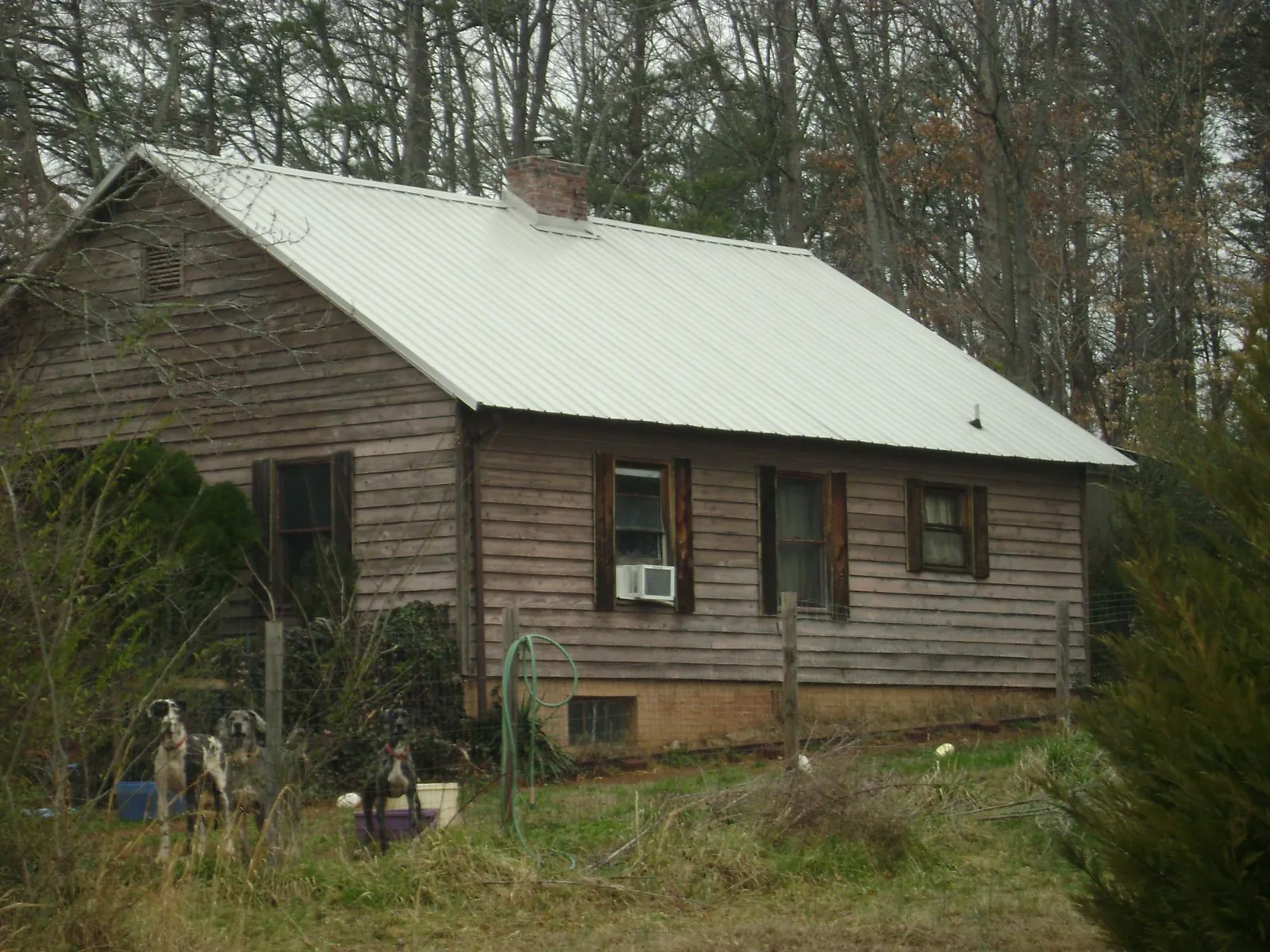 White metal roof on an old wood sided farmhouse, from a Metal Roof Installation job in Hollandale